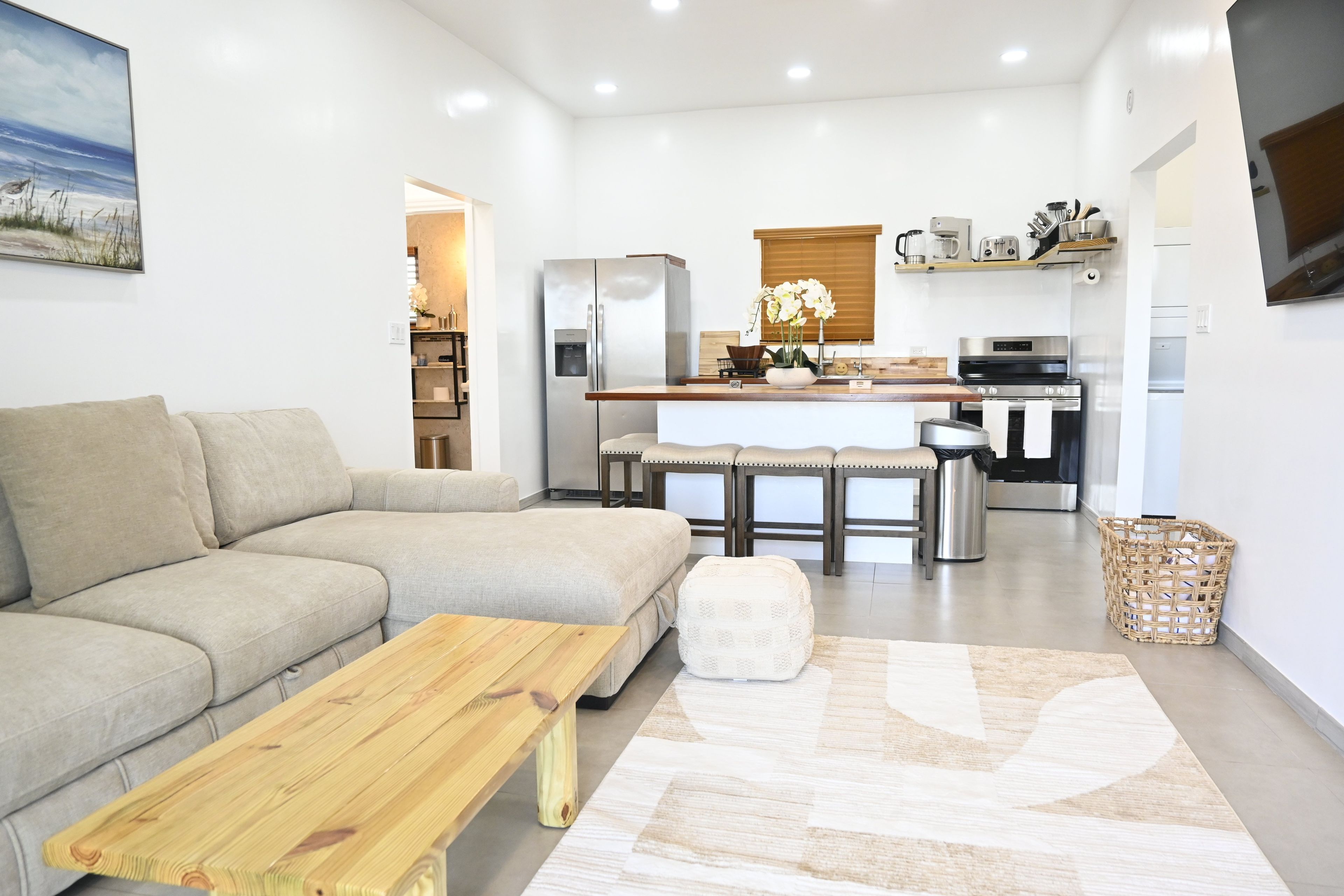 Een moderne woonkamer met een bank, een houten salontafel en een vloerkleed.