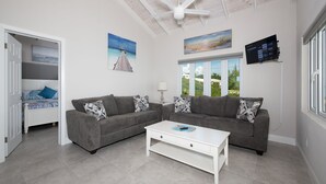 A living room with a grey sofa set, a white coffee table, and a ceiling fan.