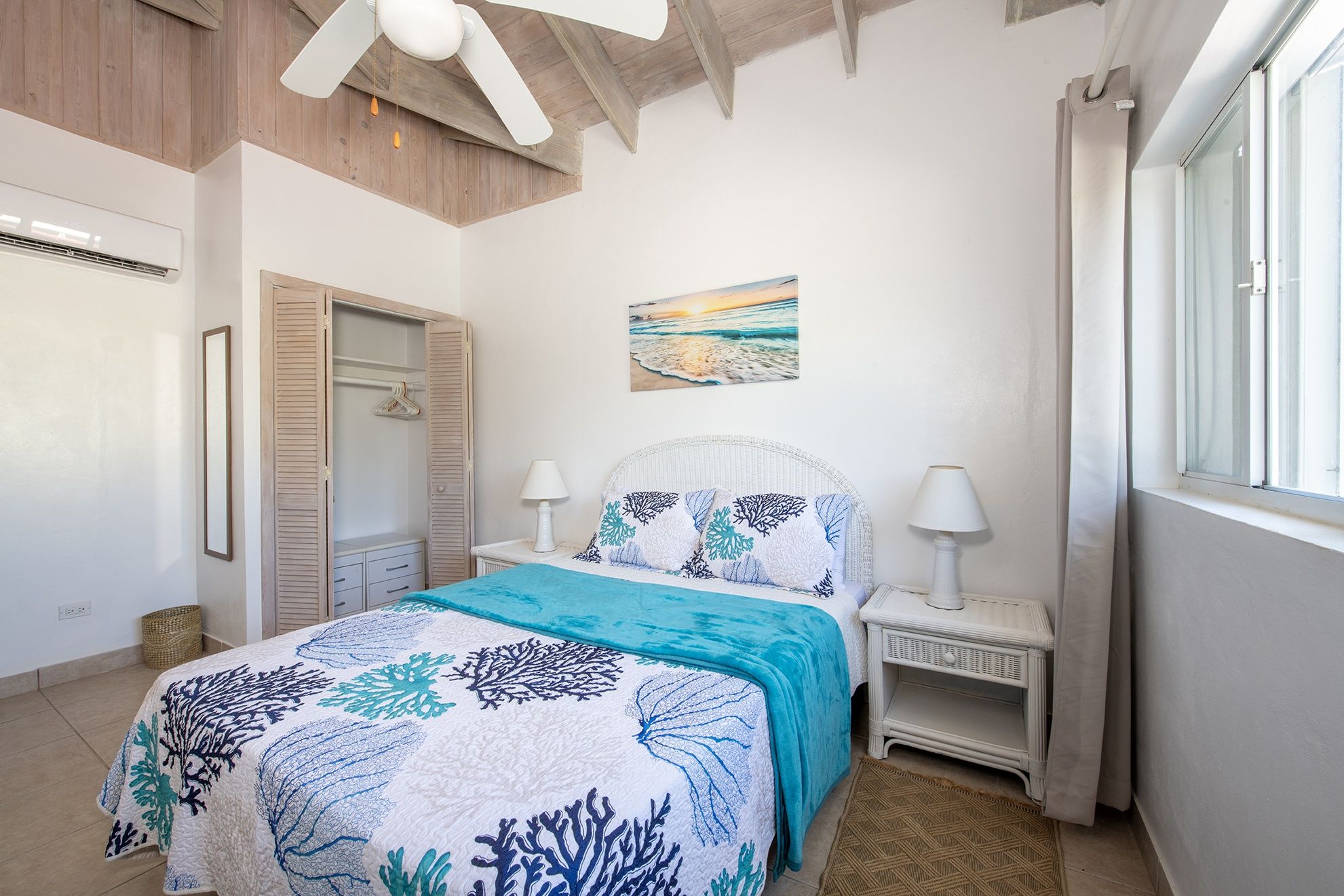 A bedroom with a bed, bedside tables, a ceiling fan, a painting, and a window.