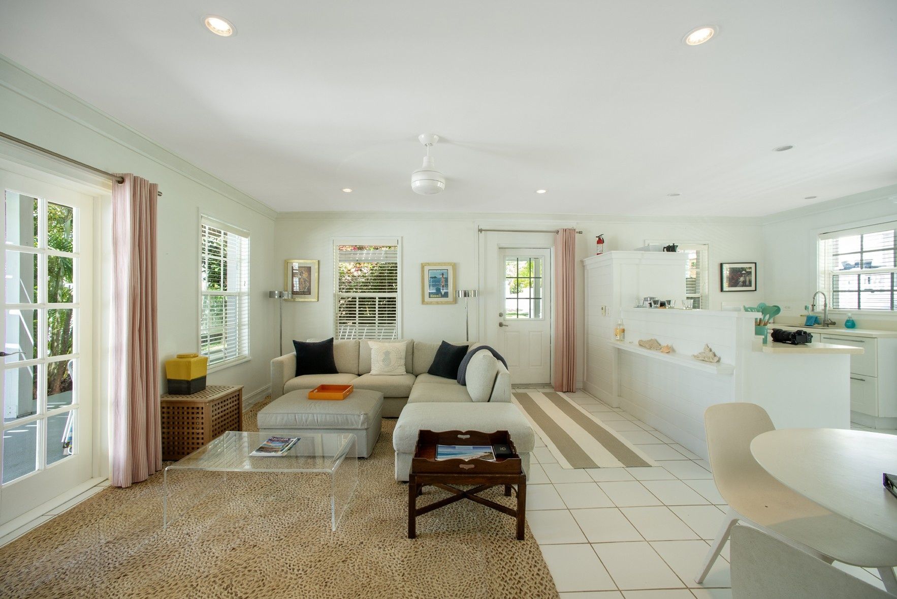 A spacious living area with a sofa, coffee table, and a dining area with a table and chairs.