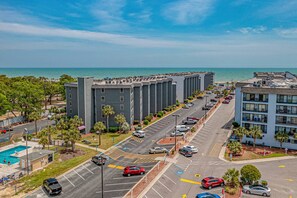 A multi-story hotel with a parking lot and a view of the ocean. - Ocean Front 2 BR | Myrtle Beach Resort - RT1902 (Myrtle Beach)