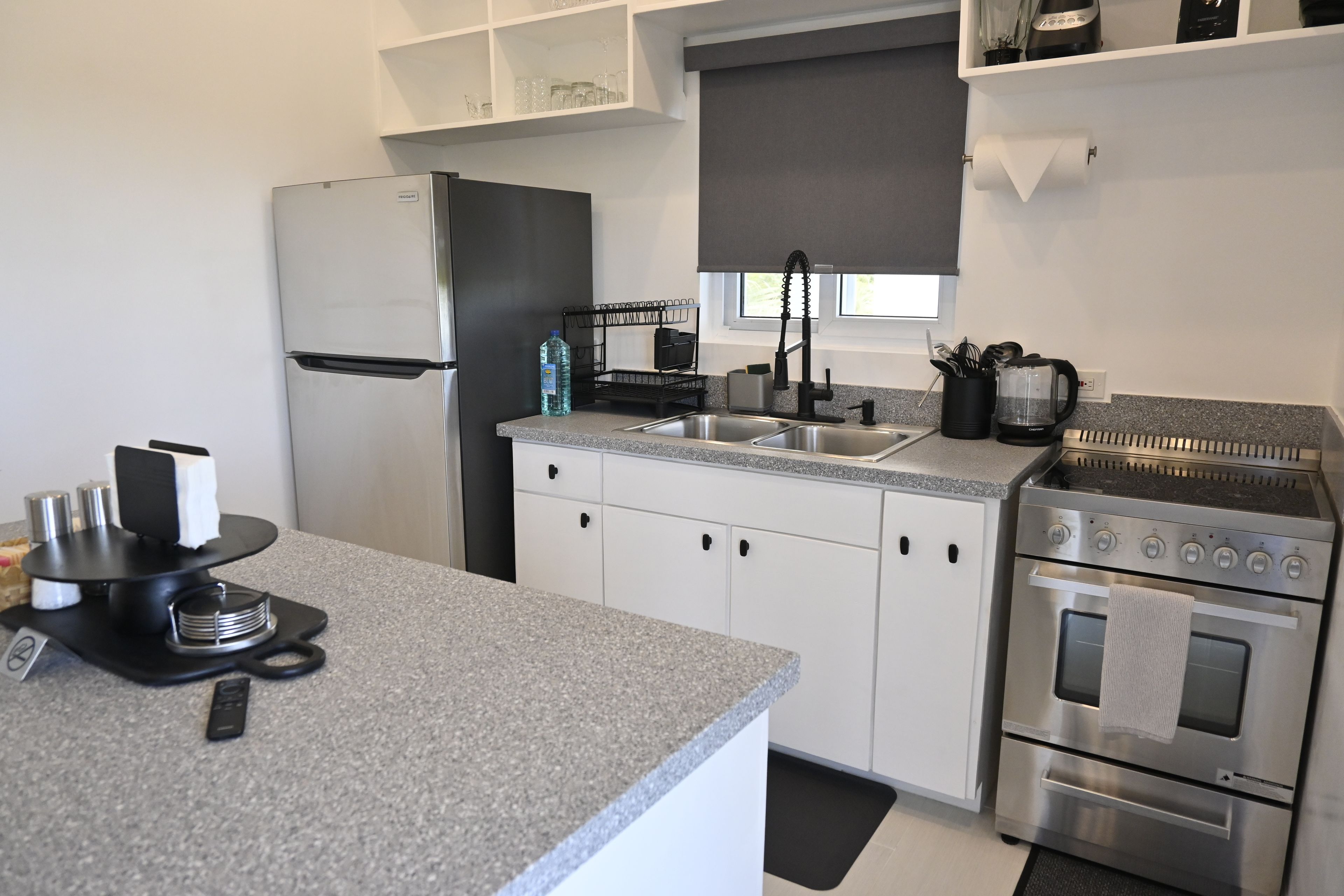 Eine moderne Küche mit einem Edelstahl-Kühlschrank, einem Backofen und einem Gasherd.