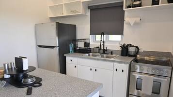 A modern kitchen with a stainless steel refrigerator, a built-in oven, and a gas stove.