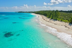 Ein Strand mit klarem türkisblauem Wasser und sandigem Ufer.
