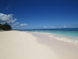 A beach with clear blue water and a sandy shore. - Shangri-la & Cottage · Tropical Beach Villa With Guest Cottage 5 Bedroom Villa (Governor's Harbour)