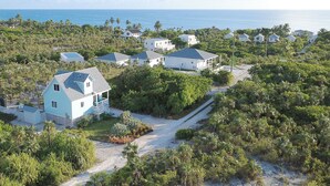 A coastal residential area with houses surrounded by dense vegetation and a clear view of the ocean. - Eagle Ray - Brand New Beach Cottage W/views, Walk To Restaurant/ 2 Bedroom Home (North Palmetto Point)