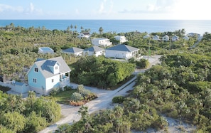 A coastal residential area with houses surrounded by dense vegetation and a clear view of the ocean. - Eagle Ray - Brand New Beach Cottage W/views, Walk To Restaurant/ 2 Bedroom Home (North Palmetto Point)