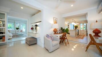 A spacious living area with a sofa, coffee table, and a dining area with chairs and a table.
