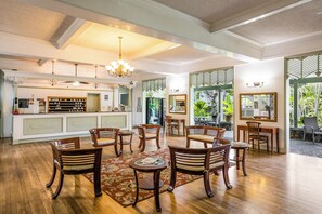 Een ruime hotellobby met een centraal zithoek, een receptiebalie en uitzicht op het omliggende landschap.