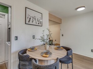 A round dining table with four chairs, a vase with a plant, and a framed picture on the wall. - 3-bedroom home in charming Midwest City with AC and fitness room (Midwest City)