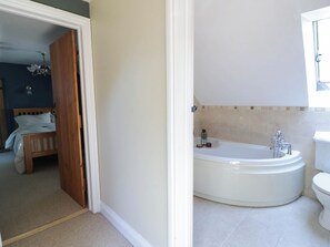 A bathroom with a bathtub, toilet, and a shower area. - Yr Hen Felin (Boncath)