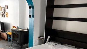 Ein Schlafzimmer mit einem Bett, einem Schreibtisch mit Computer und einem Fernseher.
