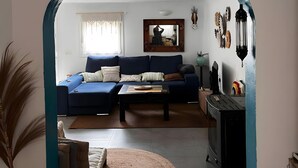 Ein Wohnzimmer mit einem blauen Sofa, einem Couchtisch und einem Kamin.
