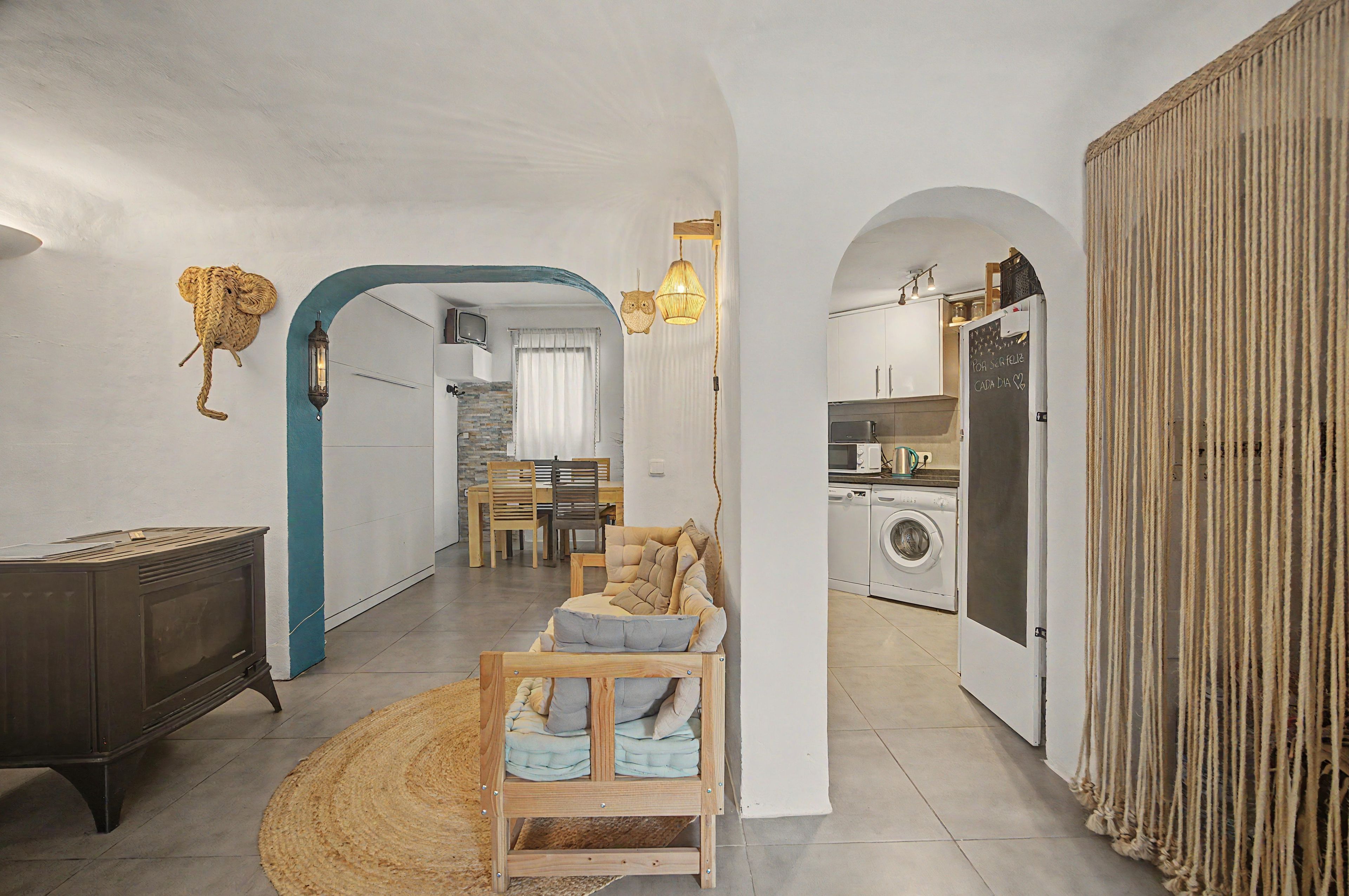 A modern interior with a dining area, kitchen, and laundry room.