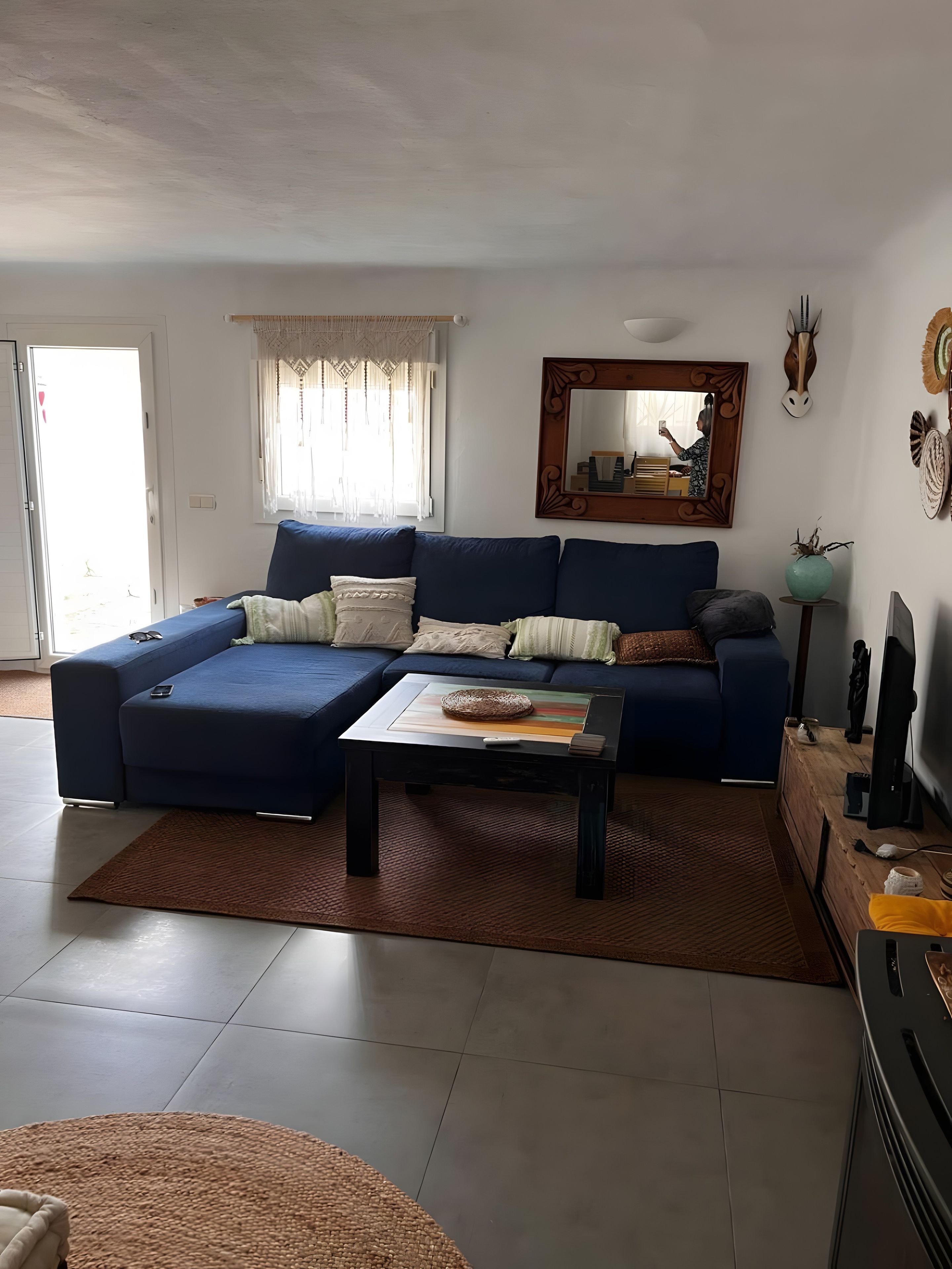 A living room with a blue sofa, a coffee table, and a television.
