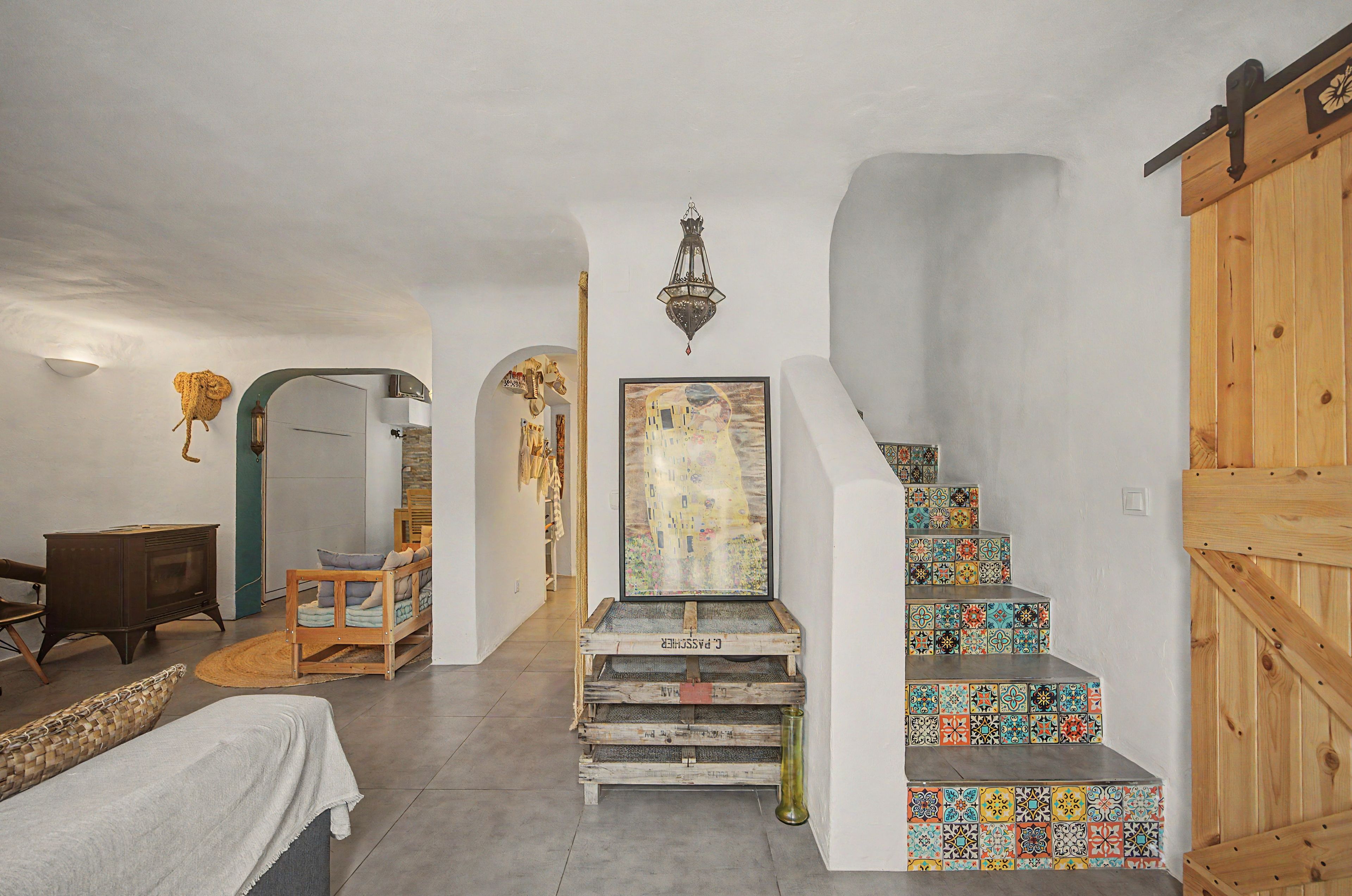A room with a wooden staircase, a painting, and a vintage radio.