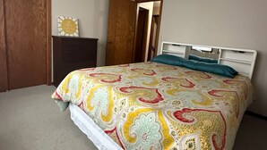 Ein Schlafzimmer mit einem Bett, einem Schminktisch und einer Tür.