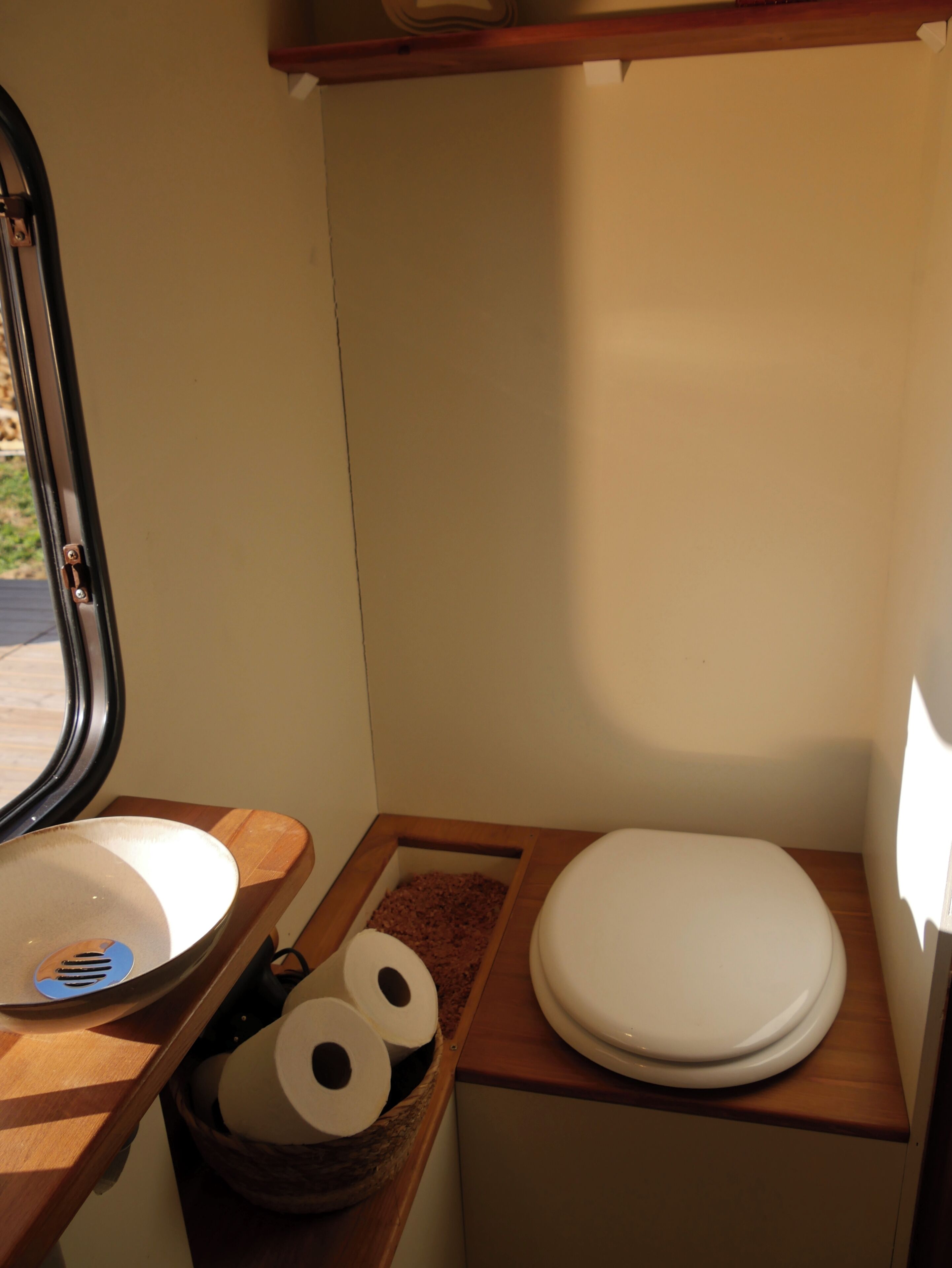 Un baño pequeño con inodoro, lavabo y una ventana.