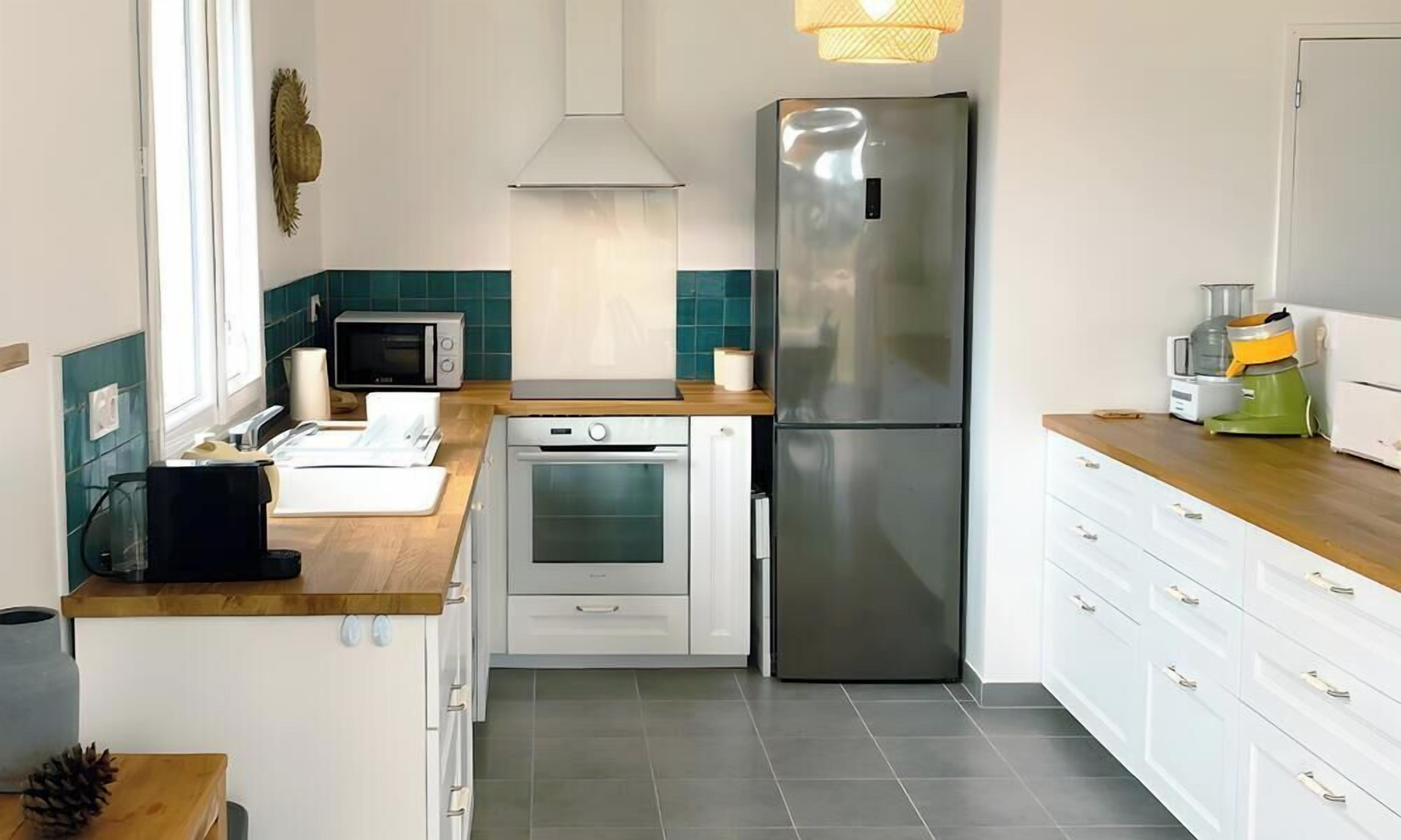 Cocina compacta con microondas, horno y refrigerador de acero inoxidable.