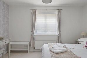 A bedroom with a bed, bedside table, and a radiator. - Comfortable Home, Garden & Parking, Walk to Beach! (Westward Ho)