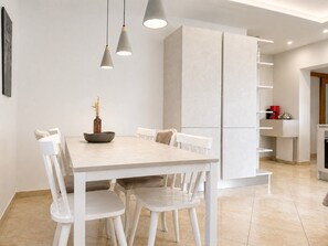 A modern kitchen with a dining table, chairs, pendant lights, and a built-in cabinet. - Holiday House with Pool and Olive Trees (Galižana)