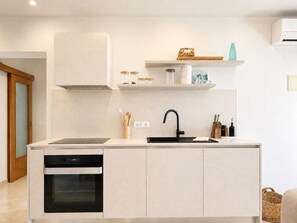 A modern kitchen with a built-in oven, a black faucet, and a countertop with a sink. - Holiday House with Pool and Olive Trees (Galižana)