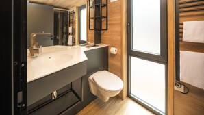 Ein modernes Badezimmer mit einem großen Waschbecken, Toilette und einem Fenster.
