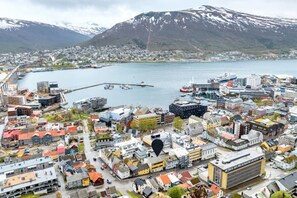 Un pueblo costero con un puerto deportivo, edificios y montañas al fondo.