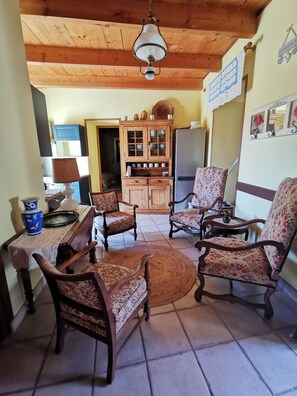 A cozy living room with wooden furniture, a dining area with a table and chairs, and a kitchen with cabinets and a refrigerator. - TWO Dog-Friendly Gites in the Cévennes with 2 Private Pools and enclosed gardens (Gagnières)
