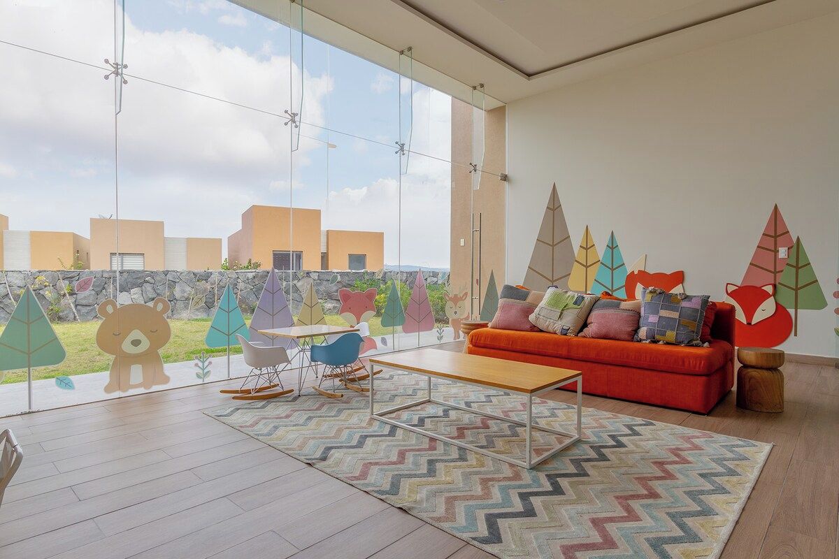 Uma sala de estar moderna com uma janela grande, um sofá, uma mesa de centro e um tapete.