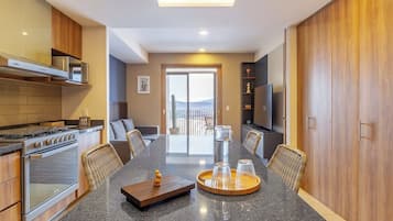 Una cocina moderna con comedor, electrodomésticos integrados y vistas a través de la puerta de vidrio.