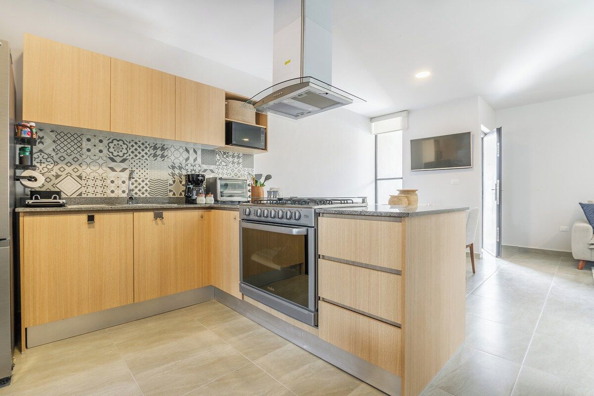 Een moderne keuken met houten kastjes, een inbouwoven en een magnetron.
