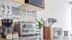 A kitchen with a toaster, coffee maker, and jars labeled 'Coffee' and 'Sugar'. - Casa Berilo  Cosmos Homes (Zakia)