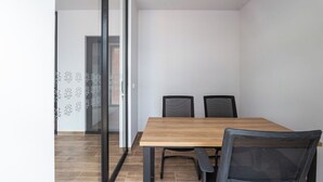 A room with a wooden table and four chairs, a glass door, and a patterned wall. - Casa Berilo  Cosmos Homes (Zakia)