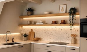 A kitchen with a speckled backsplash, wooden shelves, a hanging plant, and a built-in oven. - Luxury pond lodge with a wood-burning stove on a fishing lake (Gramsbergen)
