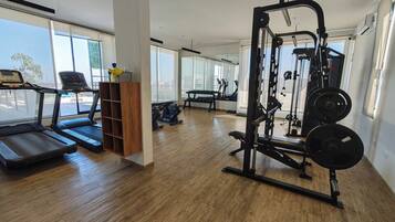 Una palestra con tapis roulant, una panca per pesi e una rack per squat.