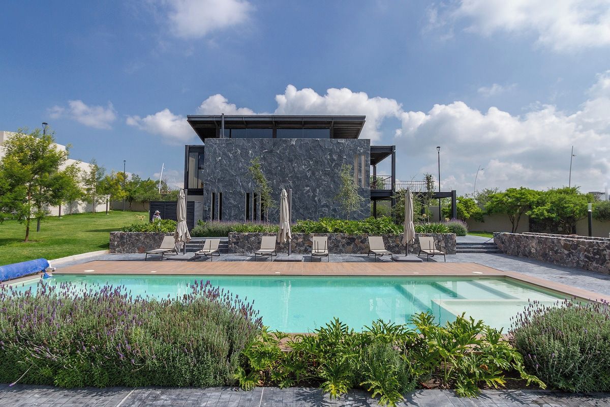 A modern building with a pool and outdoor seating area.