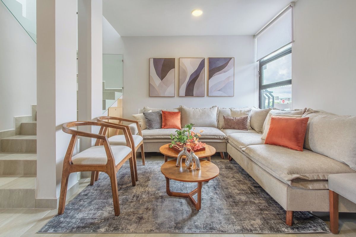 A modern living room with a sofa, chairs, a coffee table, and abstract wall art.