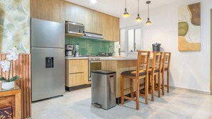 Una cucina moderna con mobili in legno, elettrodomestici in acciaio inossidabile e un'area bar con sgabelli in legno.