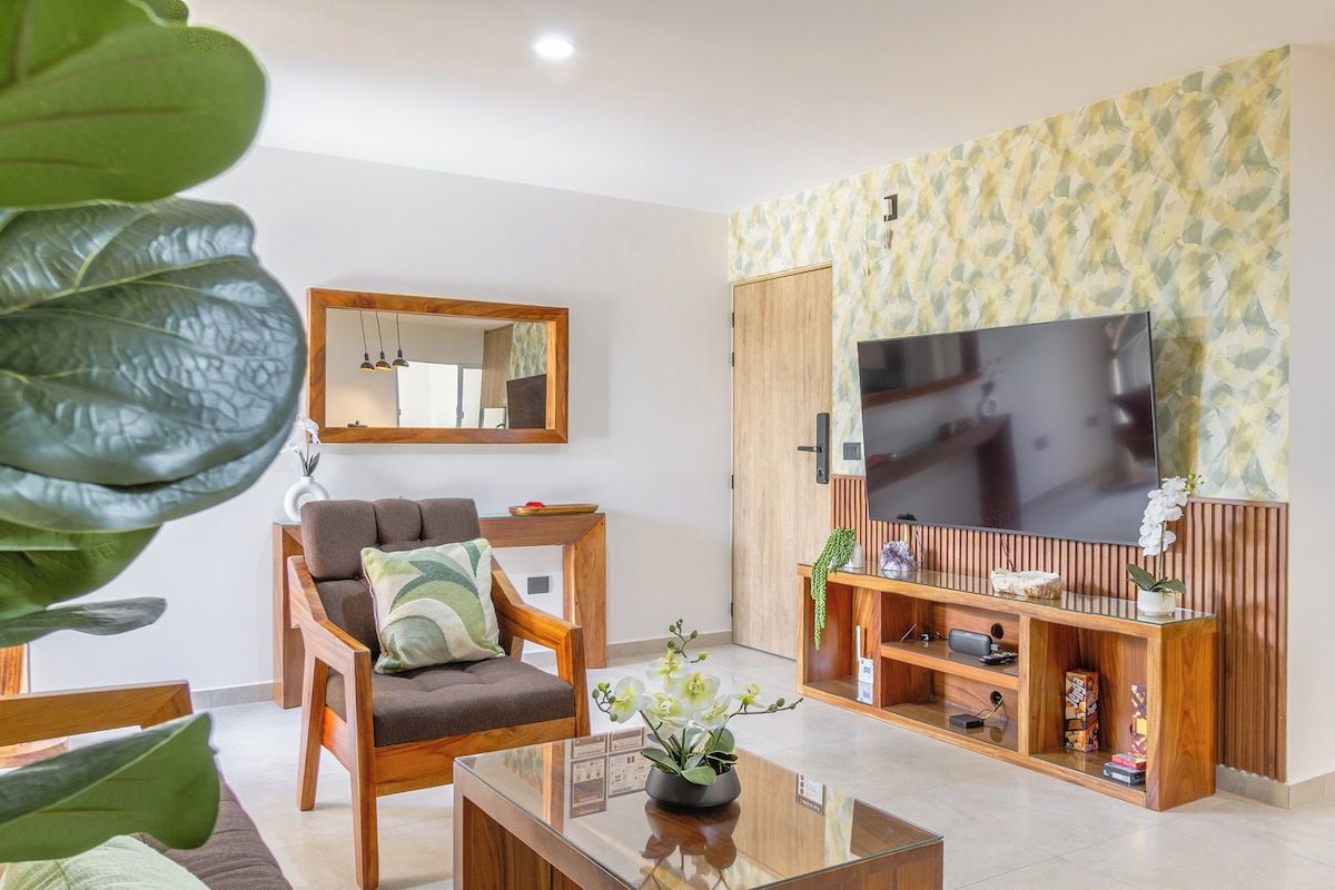 A modern living room with a sofa, a coffee table, a TV, and a wooden entertainment unit.