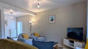 A living room with a sofa, chairs, a TV, and a lamp. - Vrbo Property (Saint-Jeures)