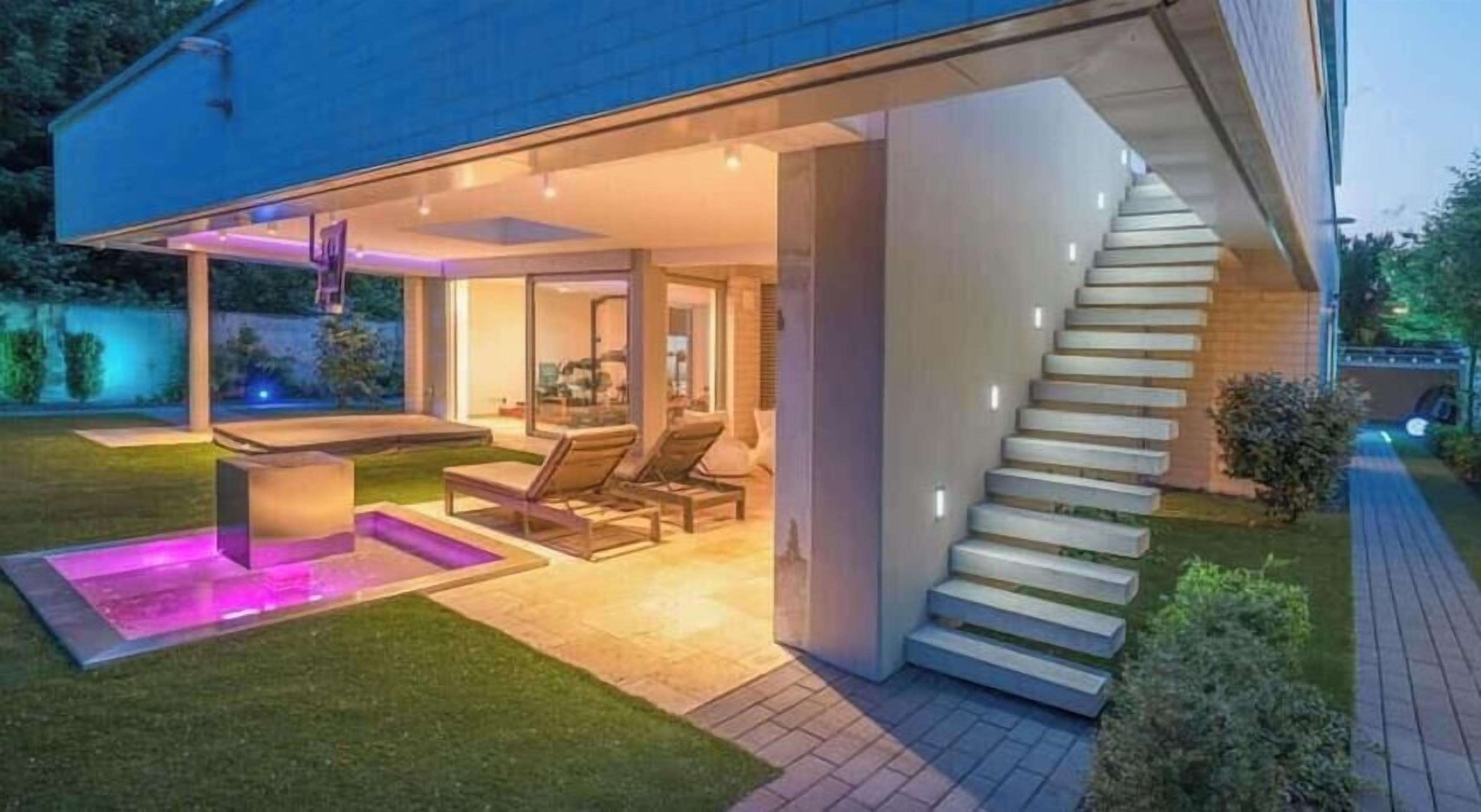 Een modern huis met een trap naar een overdekt terras.