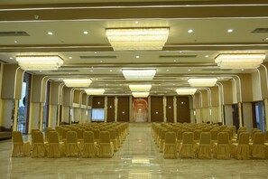 A spacious hall with rows of chairs and a large chandelier.