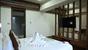 A hotel room with a bed, a television, and a wooden panel wall.