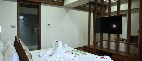 A hotel room with a bed, a television, and a wooden panel wall.