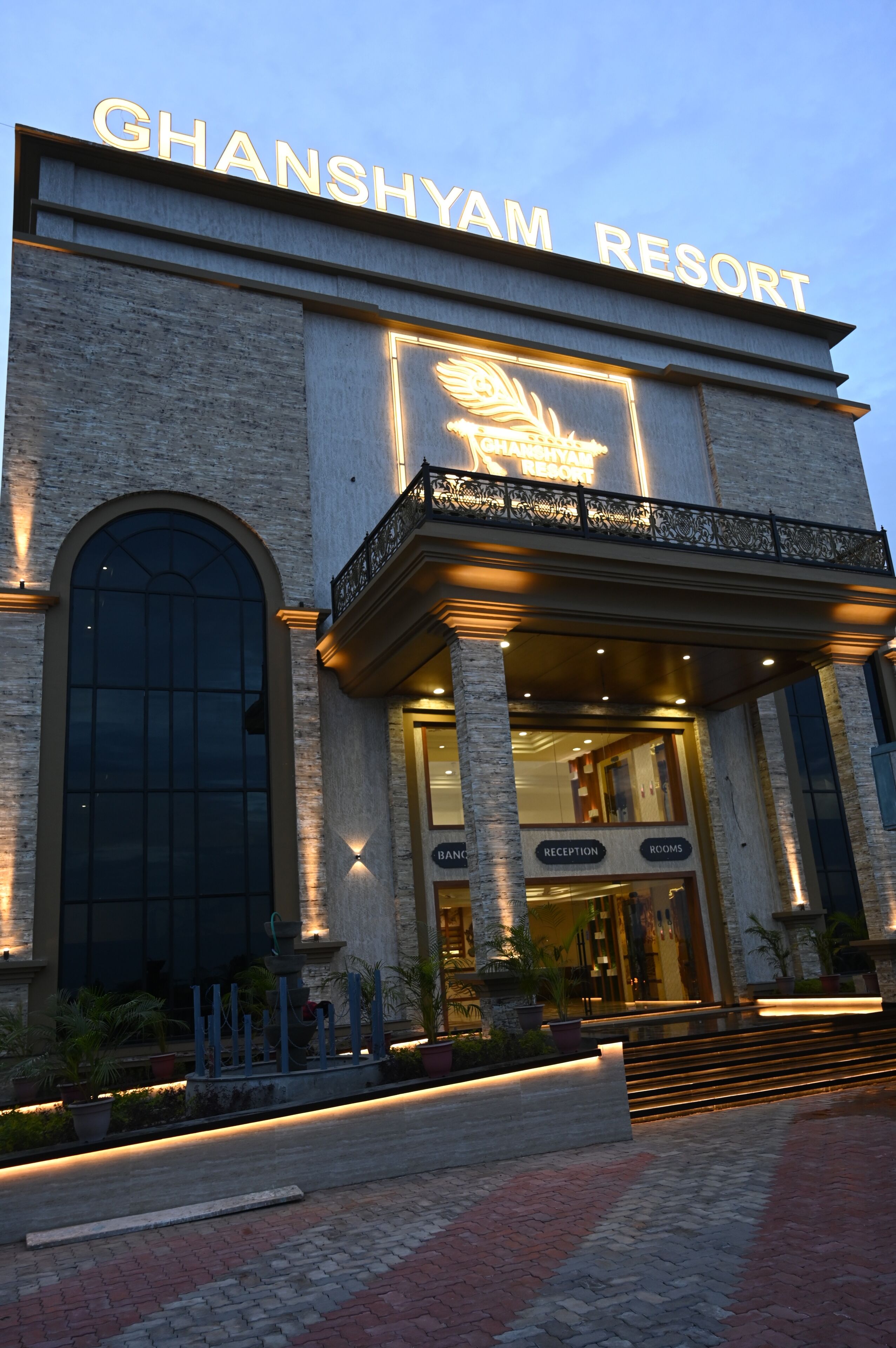 Exterior del Ghanshyam Resort con una entrada destacada, una zona de recepción y una escalera que conduce a la entrada.