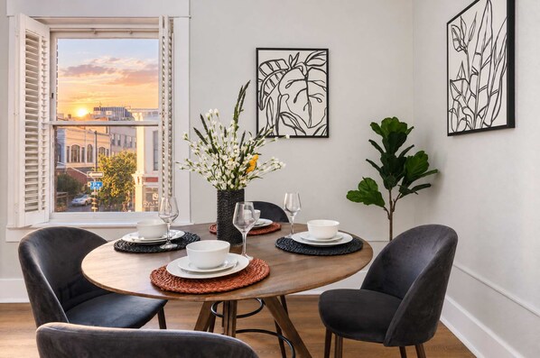 A dining area with a round table set for four, surrounded by dark chairs. - The Penn Hotel - Steps to Gaslamp & Petco Park, AC (San Diego)