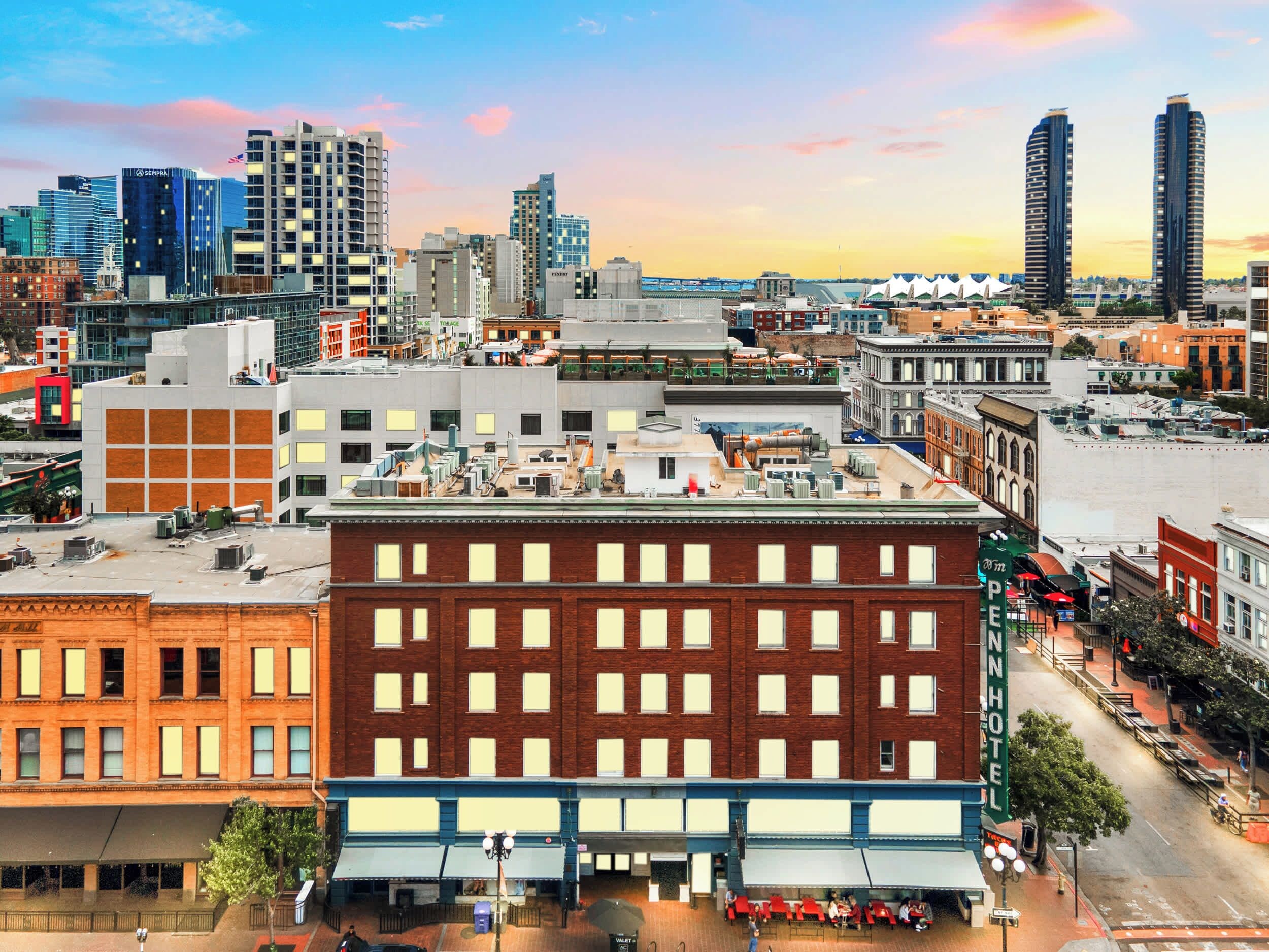 A multi-story hotel with a brick facade, large windows, and a flat roof with air conditioning units.