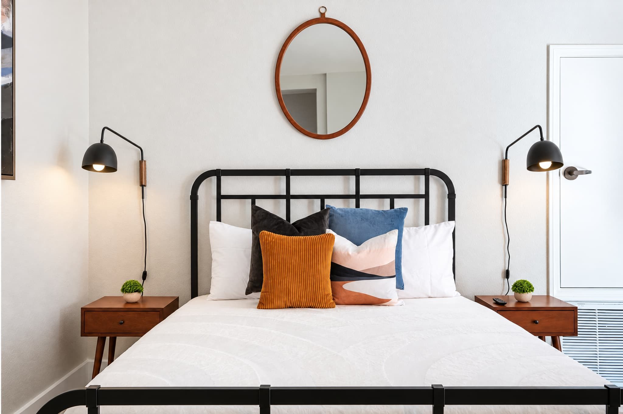 🛏️ Cozy bedside setup with vibrant accent pillows — plush textures and warm tones crafted for ultimate comfort.