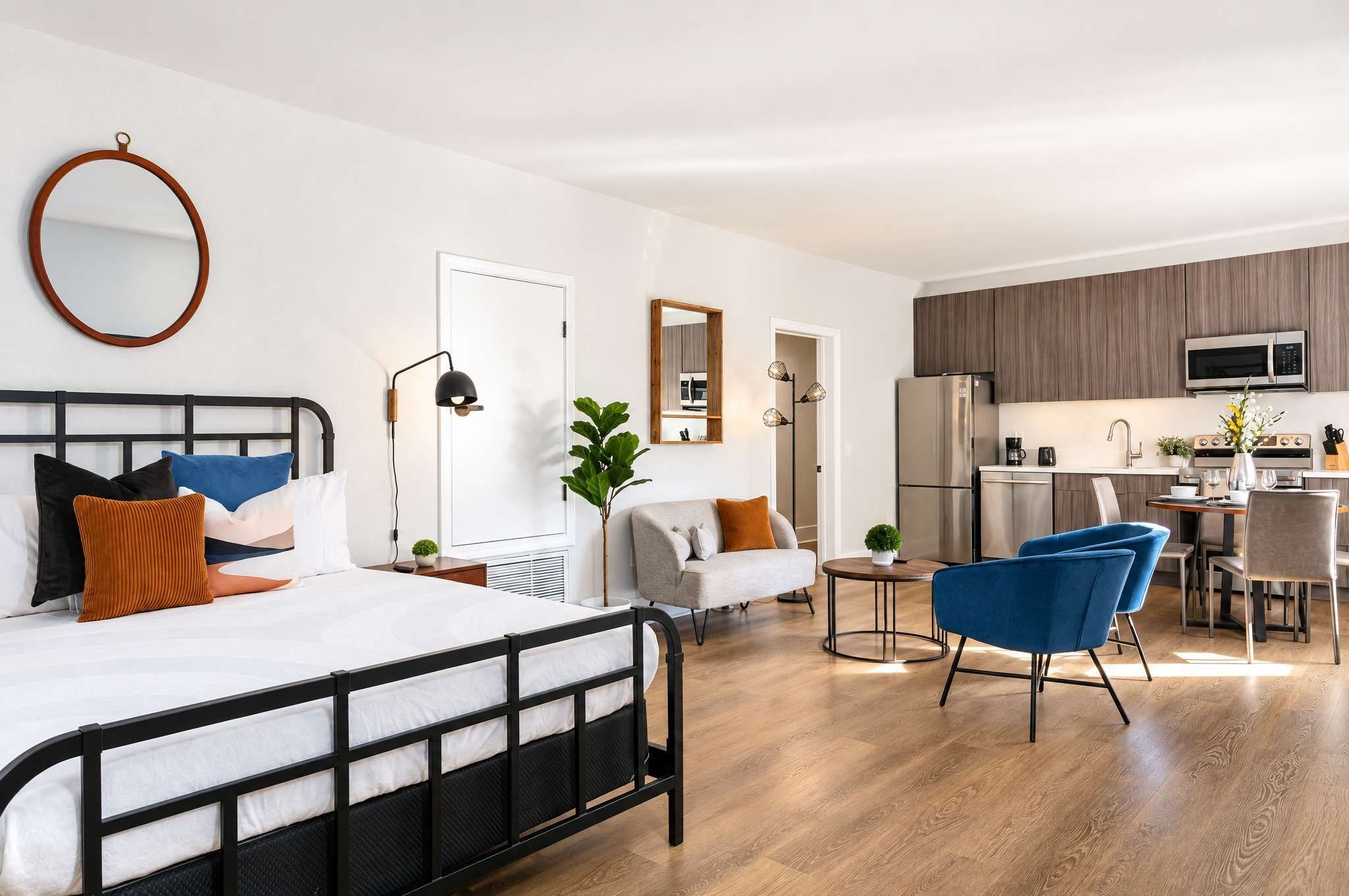 Un dormitorio moderno con cama, mesita de noche y un espejo grande.